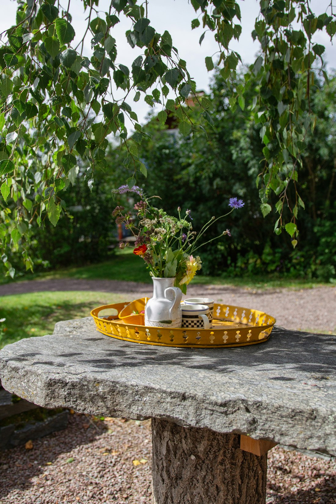 Blomster og servering på et hagebord